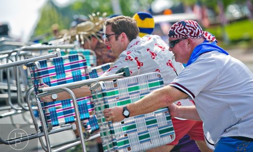 Gary Harris (right) and Grant Marshall perform a routine using lawn chairs as they march down Roswell St. and towards Historic Marietta Square during the city's Freedom Parade on Friday, July 4, 2014. 