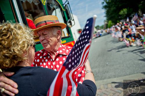 Bill Dunaway (right), former mayor of Marietta, hugs Tricia Pridemore as she marches through Historic Marietta Square during the city's  Freedom Parade on Friday, July 4, 2014. 