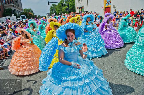 Hannah Maisel (front) waves to the crowd as she marches past Historic Marietta Square with the Mobile Azalea Trail Maids during the city's Freedom Parade on Friday, July 4, 2014. 