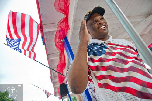 Clarence Sinkler salutes to the crowd as he rides a float towards Historic Marietta Square during the city's  Freedom Parade on Friday, July 4, 2014. 