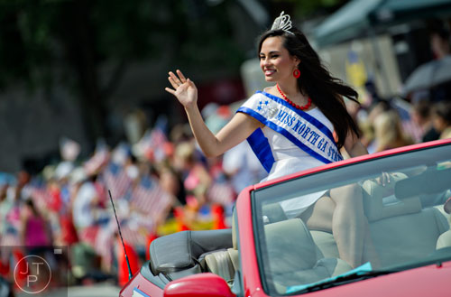Miss North GA State Fair Katherine McCauley waves to the crowd as she rides in a convertible through Historic Marietta Square during the city's  Freedom Parade on Friday, July 4, 2014. 