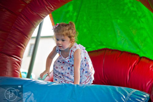 Haley Apte sits at the top of an inflatable slide in Historic Marietta Square during the city's  Fourth in the Park celebration on Friday, July 4, 2014. 
