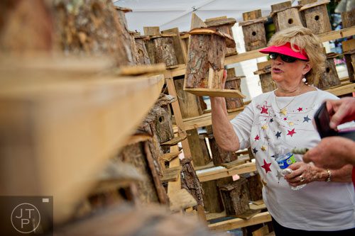 Martha Ireland chooses a hand made bird house in one of the artists booths off of  Historic Marietta Square during the city's  Fourth in the Park celebration on Friday, July 4, 2014. 