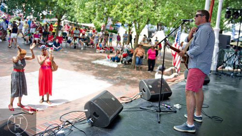 J. Scott Thompson (right) performs on stage in Historic Marietta Square as LaToya Shumate and Kathy Bass (left) dance during the city's  Fourth in the Park celebration on Friday, July 4, 2014. 