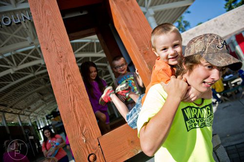Justin Coursey (right) picks up Zayden Timms on his back as Cassidy Puckett and Arrissa Timms wait their turn in front of the skylift at Stone Mountain Park during the Fantastic Fourth celebration weekend on Saturday, July 5, 2014. 