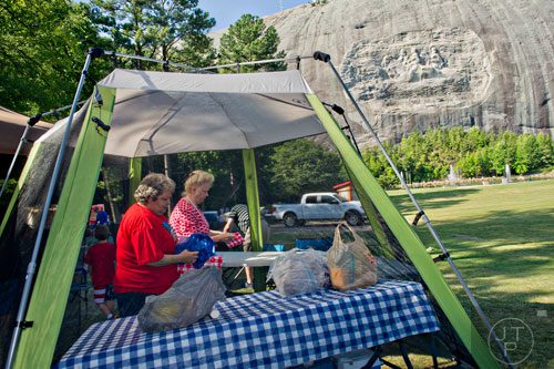 Elsie Martin (left) and Wanda Mills set up their picnic area on the main lawn at Stone Mountain Park during the Fantastic Fourth celebration weekend on Saturday, July 5, 2014.  