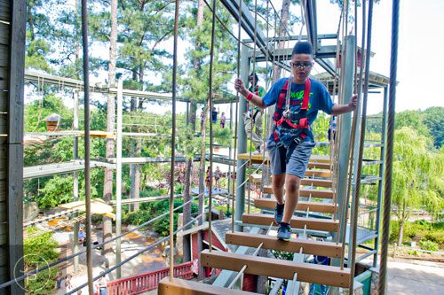 Douglas Stallworth makes his way through the SkyHike attraction at Stone Mountain Park during the Fantastic Fourth celebration weekend on Saturday, July 5, 2014. 