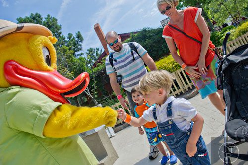 Sterling McGriff-Rinehart (right) fist bumps "Splash", one of Stone Mountain Park's mascots, as his mother Brandy and Brandon and Brent Edson wait for their turn at Stone Mountain Park during the Fantastic Fourth celebration weekend on Saturday, July 5, 2014.  