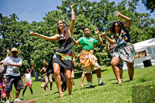 Coty Noojin (center) leads a hula dancing lesson as R.J. Isaac and his sister Deinnah try to follow along during the Nezian Festival at Grant Park in Atlanta on Saturday, July 5, 2014. 