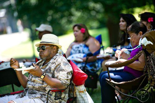 Tracy Smith (left) eats as he watches the performances during the Nezian Festival at Grant Park in Atlanta on Saturday, July 5, 2014.