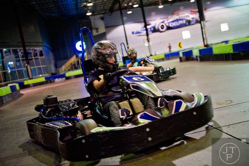 Connor Kelly (left) waves Logan Greenwood past him as they race go karts during the Pro Cup Karting summer camp in Roswell on Wednesday, July 9, 2014. 