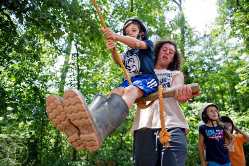 Dylan Steely (left) gets prepared to fly through the air as he is pulled back on a rope swing by Alex Marks during horseback riding summer camp at the Ellenwood Equestrian Center in Ellenwood on Wednesday, July 9, 2014.  