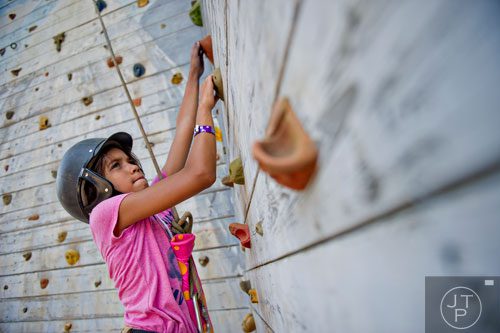 Anna Ruth Lewis climbs a rock wall during horseback riding summer camp at the Ellenwood Equestrian Center in Ellenwood on Wednesday, July 9, 2014.  