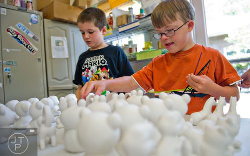 Micah Stanton (right) and Tyler Harris pick out pieces of pottery to paint during Camp Happy Hearts in Alpharetta on Tuesday, June 17, 2014. 