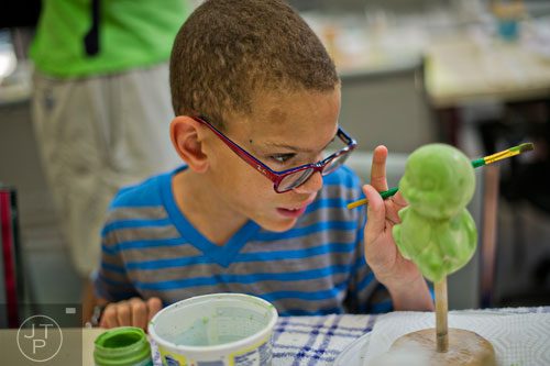 Chance Bailey paints a piece of pottery during Camp Happy Hearts in Alpharetta on Tuesday, June 17, 2014.