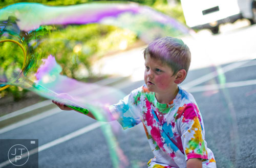 Ethan Campbell plays with bubbles during Camp Happy Hearts in Alpharetta on Tuesday, June 17, 2014. 