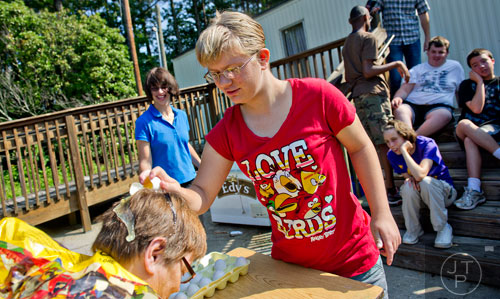 Amelia Traeger (center) cracks an egg on Elinore Trotter's head during Mad Scientist Week at the Special Needs Schools of Gwinnett Summer Enrichment Camp in Lawrenceville on Wednesday, June 18, 2014. 
