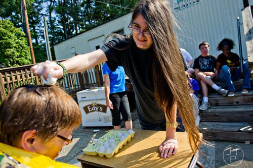 Nyssa Panetta (right) cracks an egg on Elinore Trotter's head during Mad Scientist Week at the Special Needs Schools of Gwinnett Summer Enrichment Camp in Lawrenceville on Wednesday, June 18, 2014.