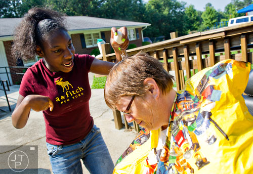 Diamond White (left) tries to crack an egg on Elinore Trotter's head during Mad Scientist Week at the Special Needs Schools of Gwinnett Summer Enrichment Camp in Lawrenceville on Wednesday, June 18, 2014.
