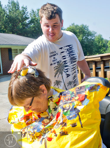 Nick Kelley (top) cracks an egg on Elinore Trotter's head during Mad Scientist Week at the Special Needs Schools of Gwinnett Summer Enrichment Camp in Lawrenceville on Wednesday, June 18, 2014. 