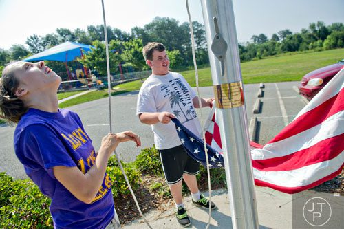 Morgan Ware (left) and Nick Kelley put an American flag on the flag pole during Mad Scientist Week at the Special Needs Schools of Gwinnett Summer Enrichment Camp in Lawrenceville on Wednesday, June 18, 2014.