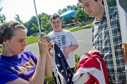 Morgan Ware (left) and Nick Kelley put an American flag on the flag pole with the help of teacher Jeff Hendrix during Mad Scientist Week at the Special Needs Schools of Gwinnett Summer Enrichment Camp in Lawrenceville on Wednesday, June 18, 2014. 