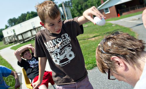 Austin Hudson tries to crack an egg on Elinore Trotter's head during Mad Scientist Week at the Special Needs Schools of Gwinnett Summer Enrichment Camp in Lawrenceville on Wednesday, June 18, 2014. 