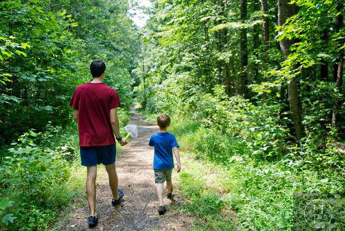Carter Percy (left) and Eli Walven hike a trail down to Sam's Creek during summer camp at Autrey Mill Nature Preserve in Johns Creek on Monday, July 14, 2014. 