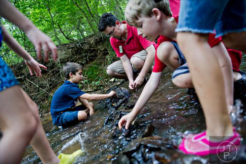 Rylan Posener (left) and Ben Pitman help build a temporary dam across Sam's Creek during summer camp at Autrey Mill Nature Preserve in Johns Creek on Monday, July 14, 2014. 