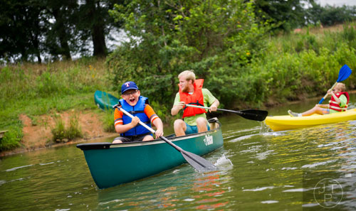 Aidan Kotheimer (left) and Nathan Hoffman paddle a canoe along the water during Camp Serenbe in Chattahoochee Hills on Tuesday, July 15, 2014. 