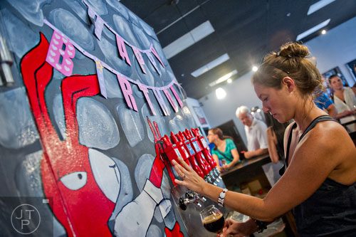 Bri Brock pours beer into a glass at Red Hare Brewery in Marietta during the company's third anniversary party on Saturday, August 23, 2014. 