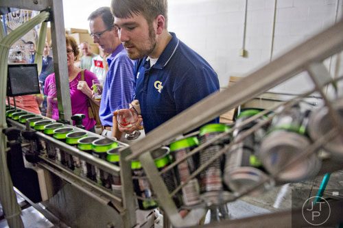 Matt Huggins (right) and Mat Schenck check out the bottling equipment at Red Hare Brewery in Marietta during the company's third anniversary party on Saturday, August 23, 2014. 