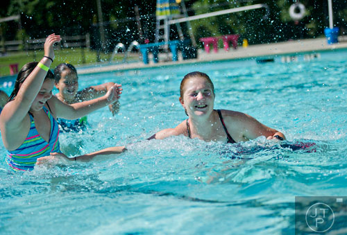 Counselor Kate Sheehy (right) reaches to try and tag Morgan Mitchell during a game of Marco Polo at Camp Timber Ridge in Mableton on Thursday, July 17, 2014.  