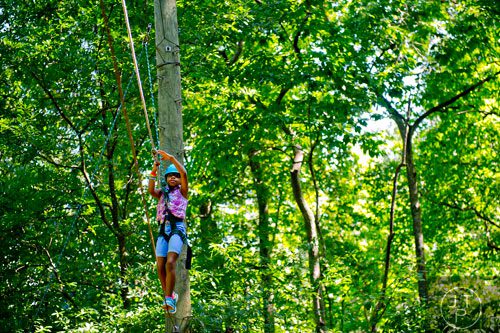 Zoe Ricardo makes her way across a wire on the high ropes course at Camp Timber Ridge in Mableton on Thursday, July 17, 2014. 