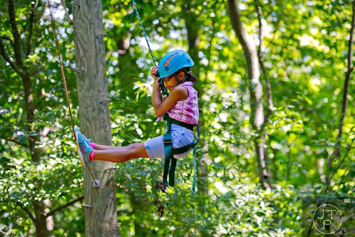 Zoe Ricardo is lowered off of a wire on the high ropes course at Camp Timber Ridge in Mableton on Thursday, July 17, 2014.