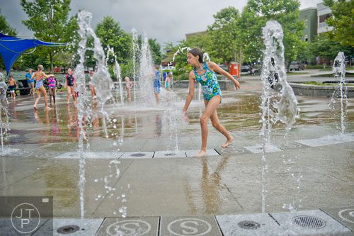Anna Sloan runs through the fountain at Town Center Park in Suwanee on Tuesday, July 22, 2014.   