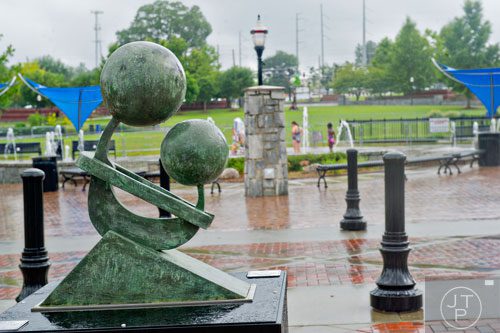 A sculpture entitled Mother & Child by Eluisa Altman sits across from the fountain at Suwanee's Town Center Park on Tuesday, July 22, 2014. 