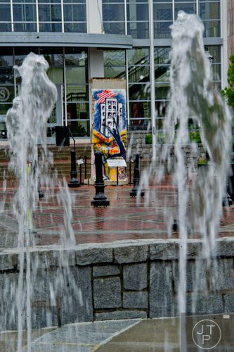 A section of the Berlin Wall stands in front of Suwanee city hall across from the fountain at Town Center Park on Tuesday, July 22, 2014.  