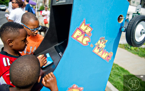 Bryce Anderson (left), Zion Jones and Christopher Callahan play a game of Ms. Pac-Man before the vehicle is set on the ground to race in the 2nd annual Cool Dads Rock Soap Box Derby at Historic Fourth Ward Park in Atlanta on Saturday, August 2, 2014. 