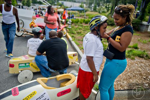 Destrie Gates (right) helps her son Elisha with his helmet before the start of the 2nd annual Cool Dads Rock Soap Box Derby at Historic Fourth Ward Park in Atlanta on Saturday, August 2, 2014.