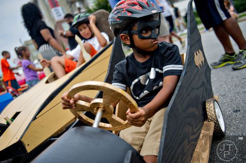 Chase Harris (right) and Benjamin Stewart sit in their vehicles as they wait for the start of the 2nd annual Cool Dads Rock Soap Box Derby at Historic Fourth Ward Park in Atlanta on Saturday, August 2, 2014. 