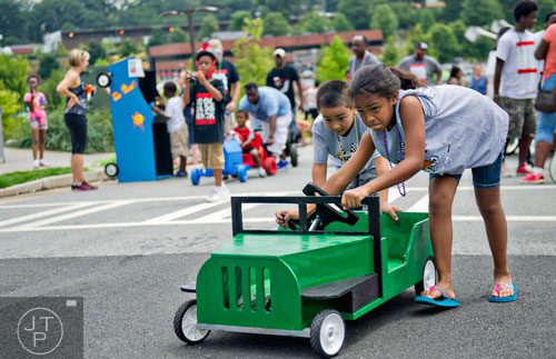 Syerra Cabantac (right) and her brother Julian push their vehicle to the starting line for the 2nd annual Cool Dads Rock Soap Box Derby at Historic Fourth Ward Park in Atlanta on Saturday, August 2, 2014.
