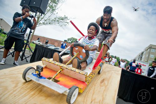 Jojo Stancil (center) gets a push from his father Jerome as he takes off from the starting line for the 2nd annual Cool Dads Rock Soap Box Derby at Historic Fourth Ward Park in Atlanta on Saturday, August 2, 2014.