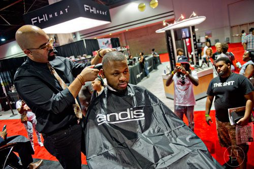 Kenny Duncan (left) works on Steven Reid's hair during the International Bronner Bros. Hair Show at the Georgia World Congress Center in Atlanta on Saturday, August 2, 2014.
