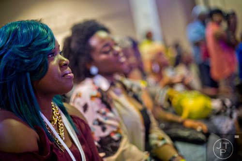 Sadari Jackson (left) watches the quick cut competition during the International Bronner Bros. Hair Show at the Georgia World Congress Center in Atlanta on Saturday, August 2, 2014. 