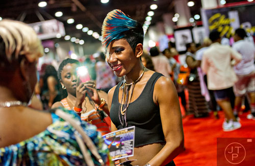 Jerrika Taylor (center) poses for photos during the International Bronner Bros. Hair Show at the Georgia World Congress Center in Atlanta on Saturday, August 2, 2014.