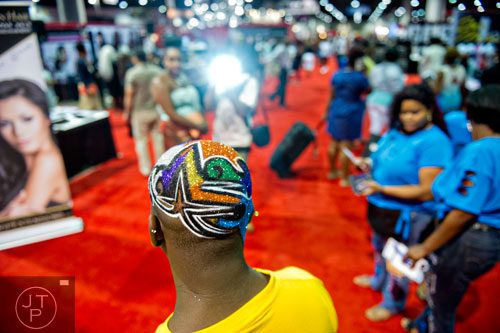 Altimar Williams (center) sports a hair design by M.C. Razor as he poses for photos during the International Bronner Bros. Hair Show at the Georgia World Congress Center in Atlanta on Saturday, August 2, 2014. 