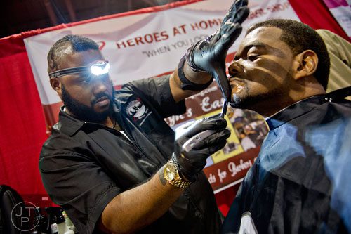 Duke Desdunes (left) uses a straight razor to clean up Dale Patterson's chin during the International Bronner Bros. Hair Show at the Georgia World Congress Center in Atlanta on Saturday, August 2, 2014. 