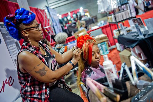 Deashia Phillips (left) works on Cynsherika Winfrey's hair during the International Bronner Bros. Hair Show at the Georgia World Congress Center in Atlanta on Saturday, August 2, 2014. 