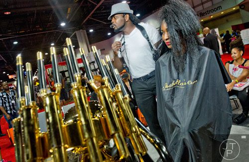 Marvin Hayes (center) talks to the crowd as he works on Tomecia Bradley's hair during the International Bronner Bros. Hair Show at the Georgia World Congress Center in Atlanta on Saturday, August 2, 2014.
